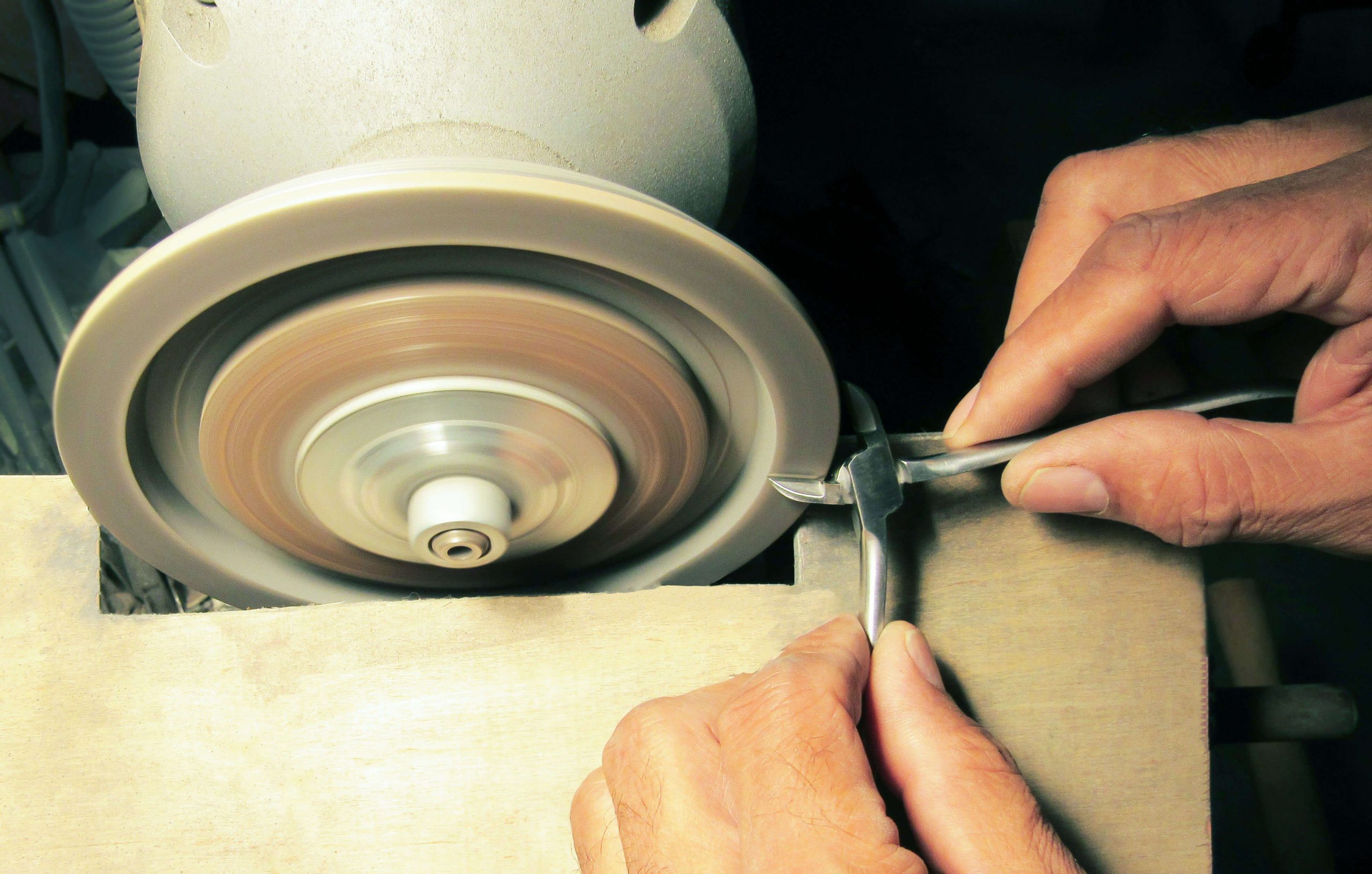 a person is polishing a pair of scissors on a machine